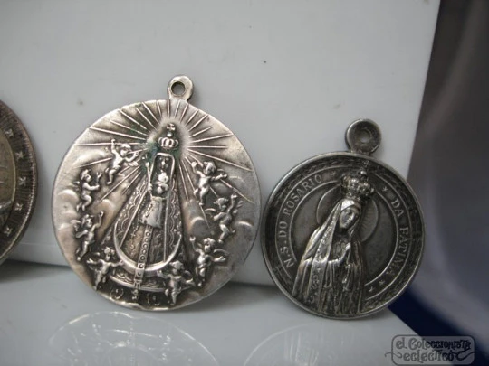 Four medals. Sterling silver. Virgin and Saints. Relief. 1920's