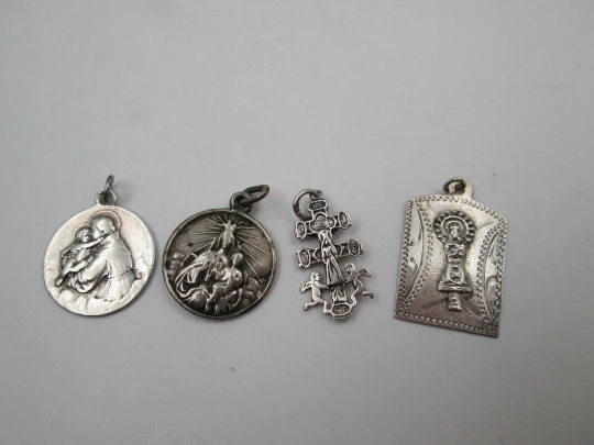 Four religious medals. Sterling silver. Christ, cross, virgin and saint. Spain. 1925-1970's Four religious medals. Sterling silver. Christ, cross, virgin and saint. Spain. 1925-1970's