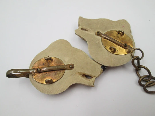 Gentleman's cape / cloak clasp. Grey resin and golden metal. Wolves heads. Europe. 1950's