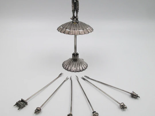 Juego de seis pinchos para aperitivos con soporte figura gaitero. Metal plateado. 1980
