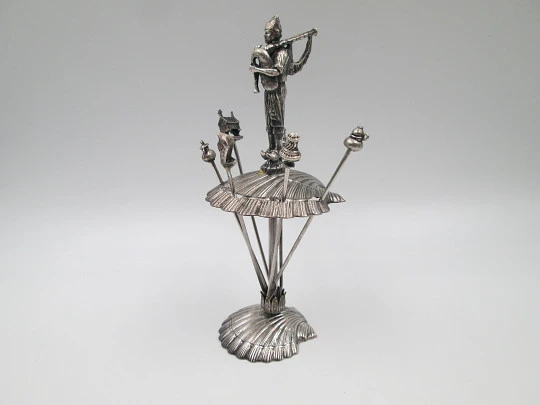 Juego de seis pinchos para aperitivos con soporte figura gaitero. Metal plateado. 1980