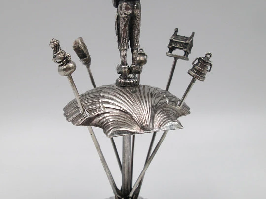 Juego de seis pinchos para aperitivos con soporte figura gaitero. Metal plateado. 1980