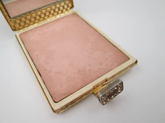 Ladie's powder compact. Gold plated with ornate pattern. White gems clasp. 1950's
