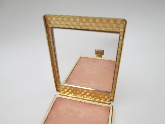 Ladie's powder compact. Gold plated with ornate pattern. White gems clasp. 1950's