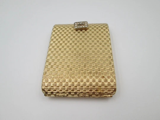 Ladie's powder compact. Gold plated with ornate pattern. White gems clasp. 1950's