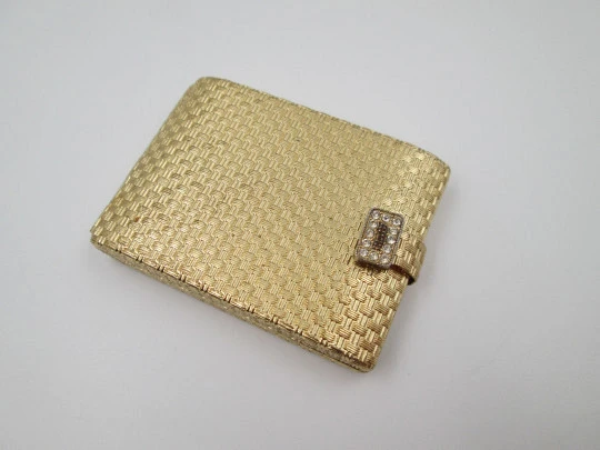 Ladie's powder compact. Gold plated with ornate pattern. White gems clasp. 1950's