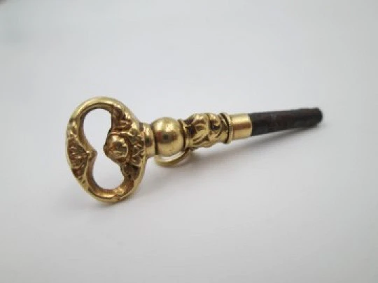 Llave para reloj de bolsillo. Oro amarillo 18k. Flores y hojas. 1880. Argolla