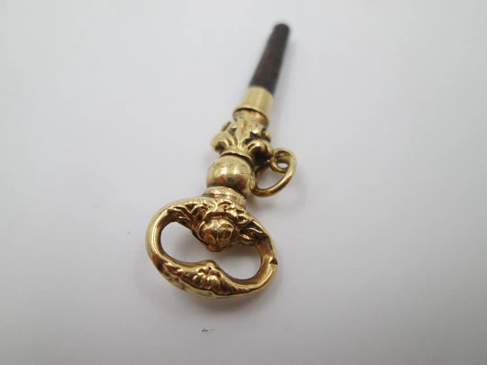 Llave para reloj de bolsillo. Oro amarillo 18k. Flores y hojas. 1880. Argolla