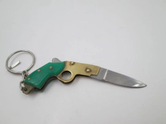 Llavero navaja de bolsillo con forma de pistola. Acero, metal dorado y resina verde. 1980