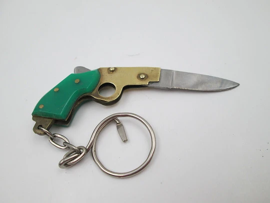 Llavero navaja de bolsillo con forma de pistola. Acero, metal dorado y resina verde. 1980