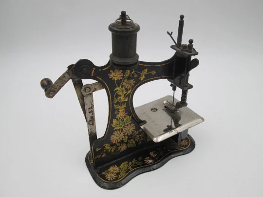 Máquina de coser de juguete en miniatura. Hojalata litografiada. Europa. 1900