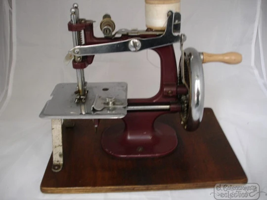Máquina de coser miniatura. 1940. Metal granate y base de madera
