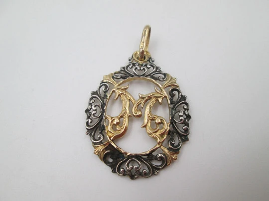 Medalla calada anagrama de la Virgen María. Plata de ley y vermeil. Cerco vegetal. 1970
