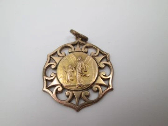 Medalla calada metal dorado. Ángel de la Guarda. Volutas y triángulos. 1940