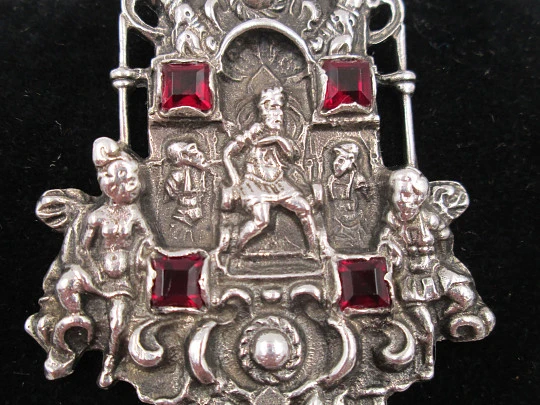 Medalla colgante pórtico. Plata de ley y granates. Escena relieve rey con querubines