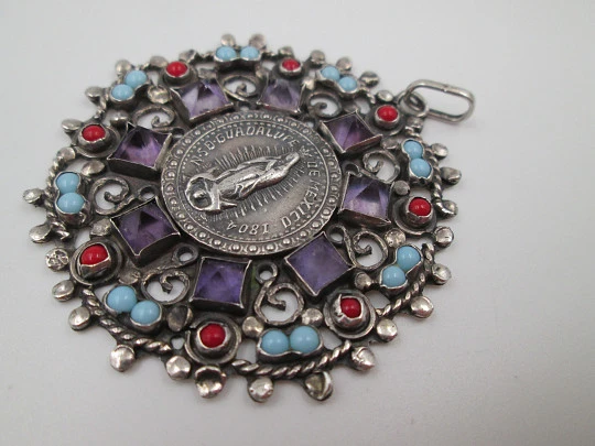Medalla colgante Virgen de Guadalupe. Plata de ley. Amatistas, turquesas y corales. 1960