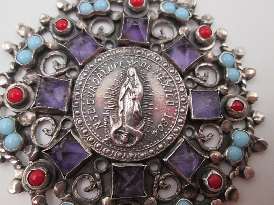 Medalla colgante Virgen de Guadalupe. Plata de ley. Amatistas, turquesas y corales. 1960