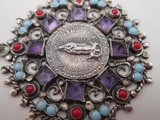 Medalla colgante Virgen de Guadalupe. Plata de ley. Amatistas, turquesas y corales. 1960