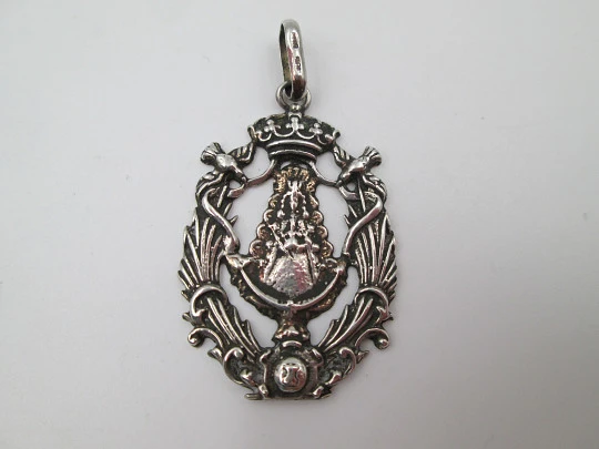 Medalla religiosa calada. Virgen María con manto y bastón de mando. Plata de ley. 1960