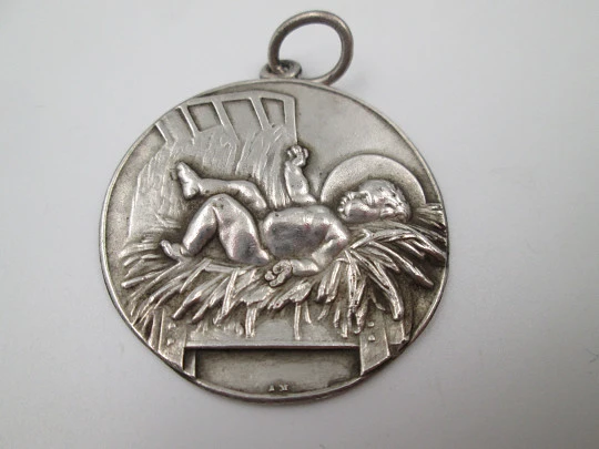 Medalla religiosa de cuna. Niño Jesús acostado entre pajas. Plata de ley. 1940