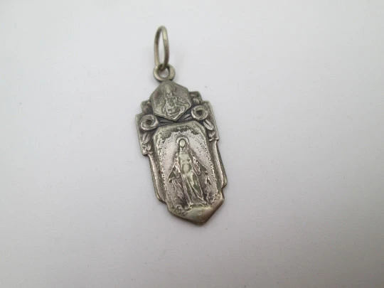 Medalla religiosa. Virgen María y Jesucristo. Metal plateado. Asa y argolla. Francia. 1940