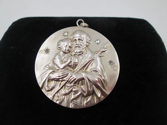 Medalla San José con el Niño. Plata de ley y gemas blancas. Alto relieve. 1950. España