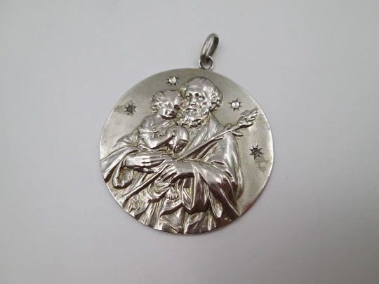 Medalla San José con el Niño. Plata de ley y gemas blancas. Alto relieve. 1950. España
