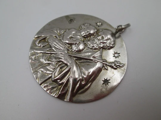 Medalla San José con el Niño. Plata de ley y gemas blancas. Alto relieve. 1950. España