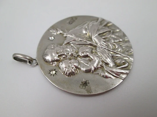 Medalla San José con el Niño. Plata de ley y gemas blancas. Alto relieve. 1950. España