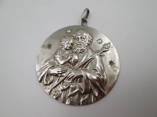 Medalla San José con el Niño. Plata de ley y gemas blancas. Alto relieve. 1950. España
