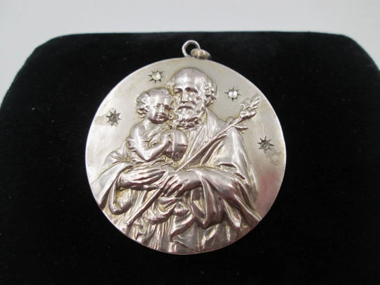 Medalla San José con el Niño. Plata de ley y gemas blancas. Alto relieve. 1950. España