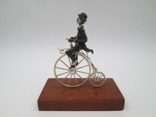 Miniatura escultura plata de ley bitono. Caballero con bastón en biciclo. 1980