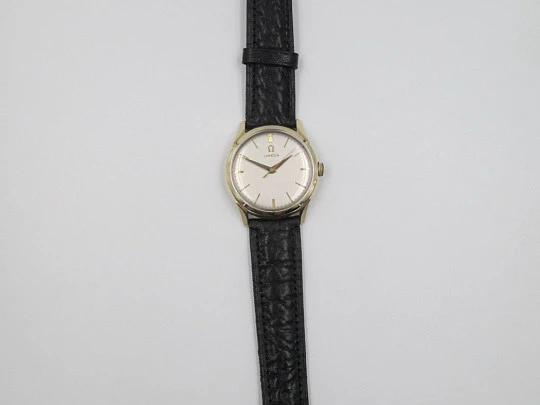 Omega. Laminado oro amarillo 14 quilates. Cuerda manual. Correa piel. 1950