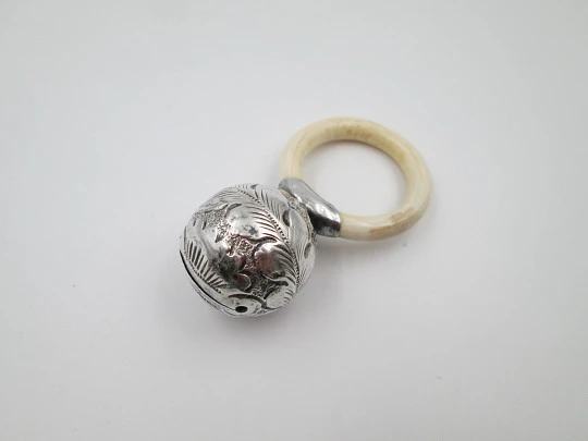 Ornate sphere baby rattle. Sterling silver. Vegetable motifs. White resin ring. 1970's