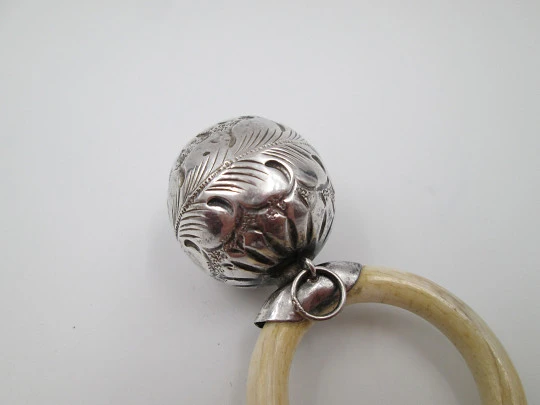 Ornate sphere baby rattle. Sterling silver. Vegetable motifs. White resin ring. 1970's