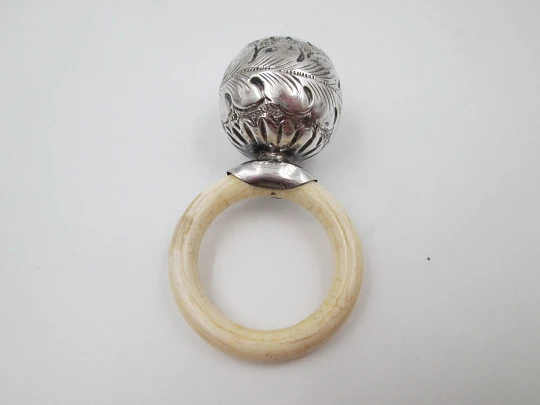 Ornate sphere baby rattle. Sterling silver. Vegetable motifs. White resin ring. 1970's