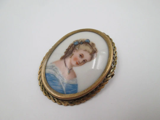 Oval brooch. Limoges painted porcelain and golden metal. Woman bust. 1950's