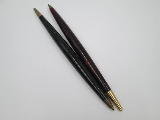 Pareja de bolígrafos. Resina marmolizada roja y gris y metal dorado. 1950