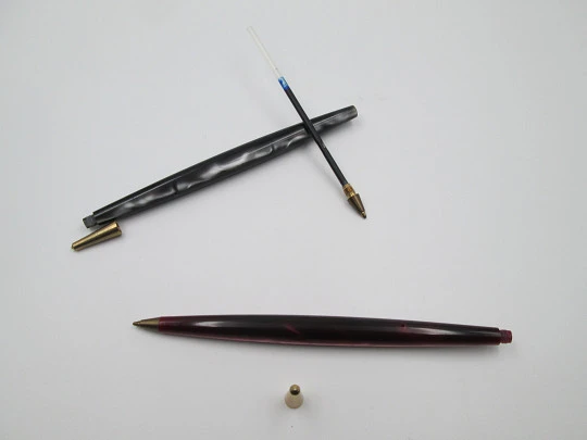 Pareja de bolígrafos. Resina marmolizada roja y gris y metal dorado. 1950