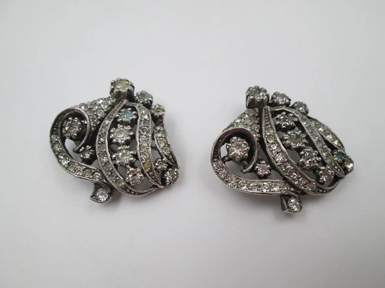Pareja de broches / clips de vestir para mujer. Metal plateado y pedrería. Francia. 1910