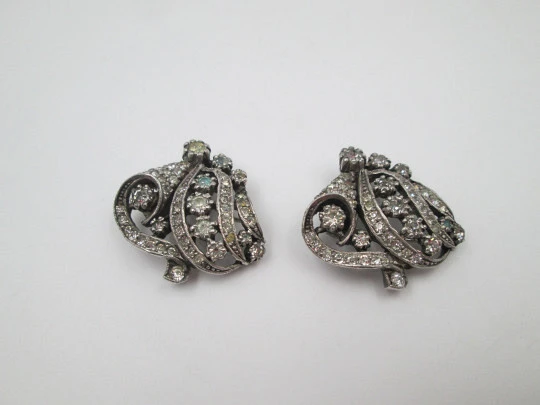 Pareja de broches / clips de vestir para mujer. Metal plateado y pedrería. Francia. 1910