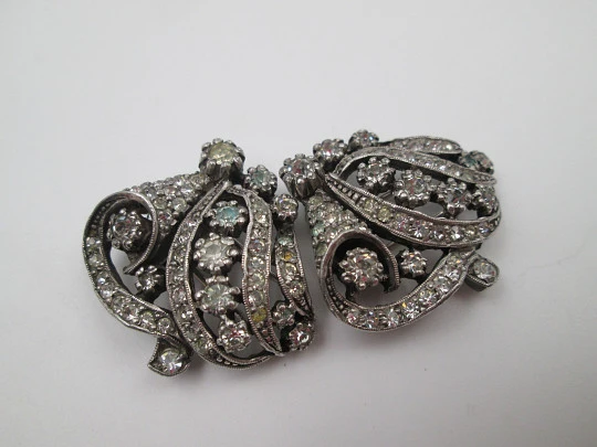 Pareja de broches / clips de vestir para mujer. Metal plateado y pedrería. Francia. 1910