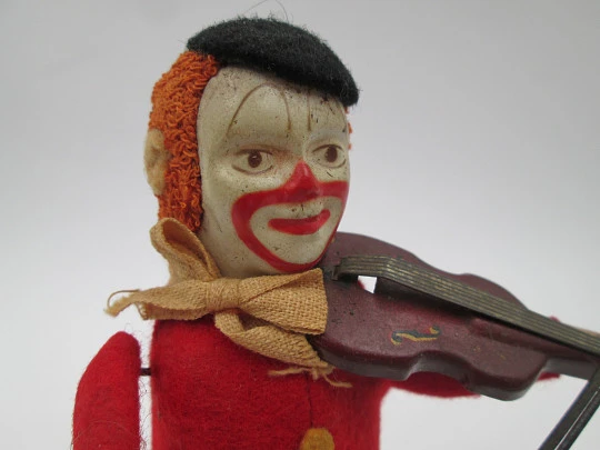 Payaso violinista mecánico Schuco. Hojalata y fieltro. Cuerda a llave. Alemania. 1930