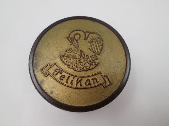 Pelikan round garnet bakelite box with golden front. Screw lid top. Germany. 1950's