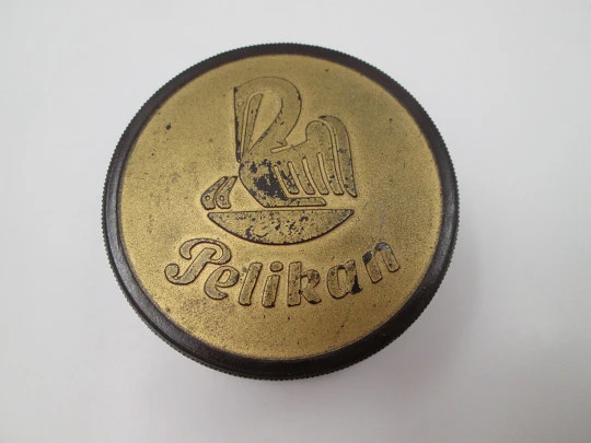 Pelikan round garnet bakelite box with golden front. Screw lid top. Germany. 1950's