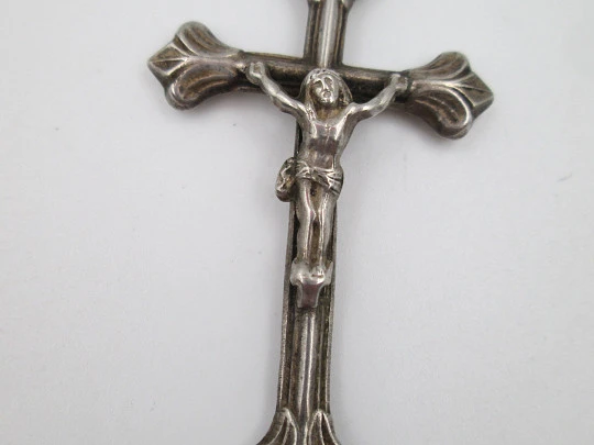 Pequeña cruz crucifijo colgante con remates en flor de lis. Plata de ley. Asa y argolla. 1950