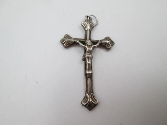Pequeña cruz crucifijo colgante con remates en flor de lis. Plata de ley. Asa y argolla. 1950