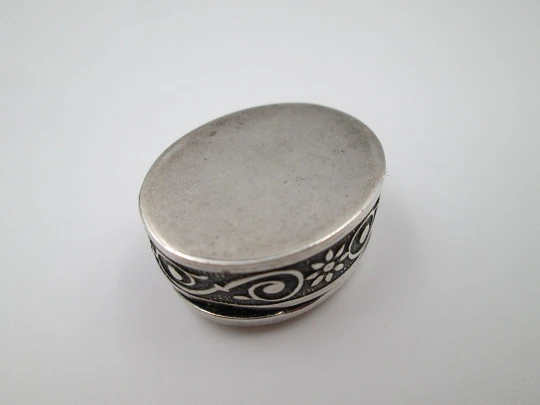 Pequeño pastillero oval en plata de ley. Motivos vegetales y escudo. Europa. 1980