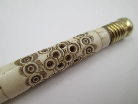 Pincushion. Carved openwork bone and golden metal. Circular pattern