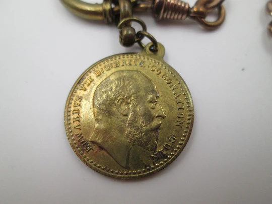 Pocket watch chain. Open braided links. Gold plated. Coin pendant. 1911